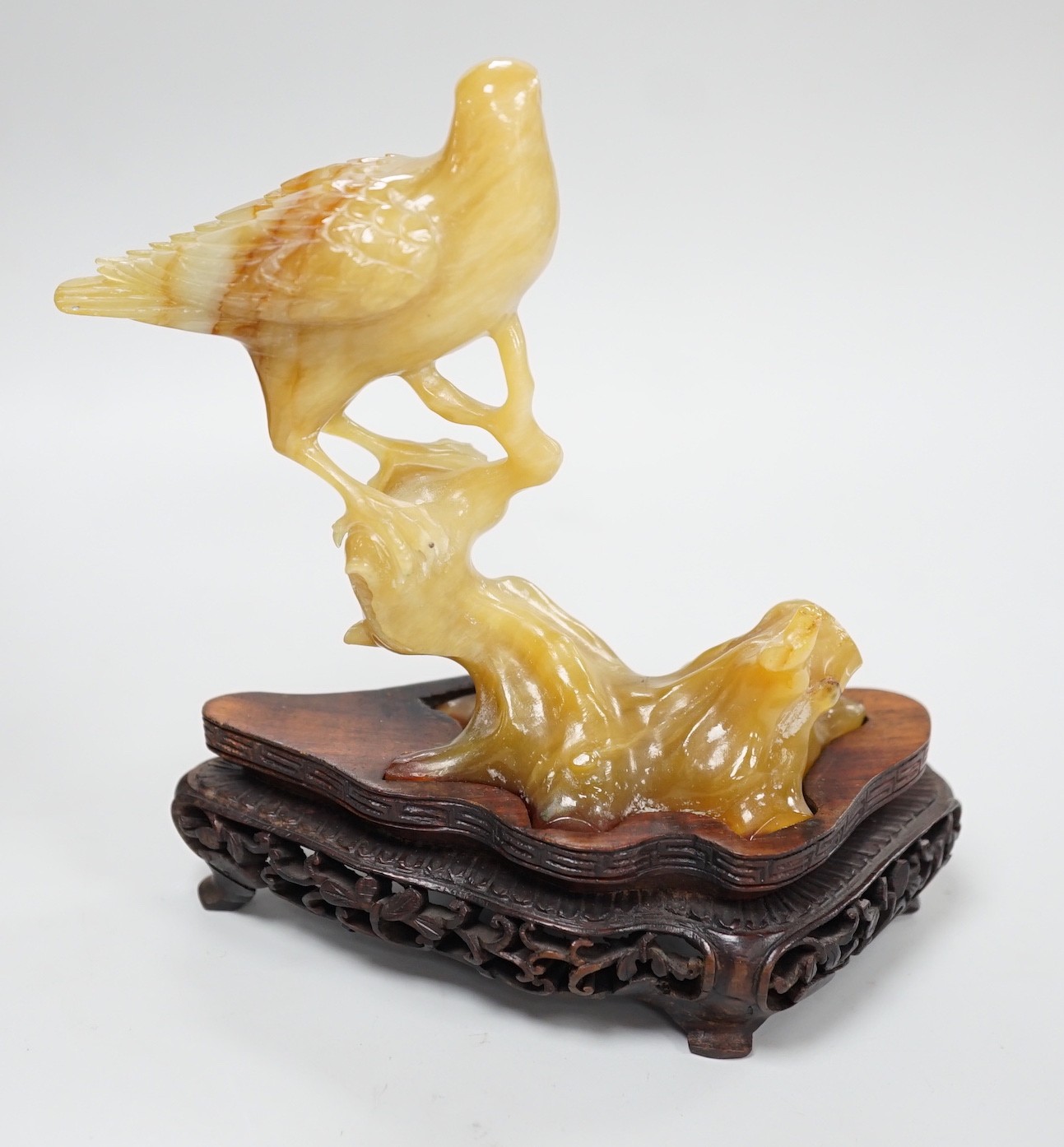 A Chinese chalcedony carving of a bird, wood stand, total height 15.5 cm